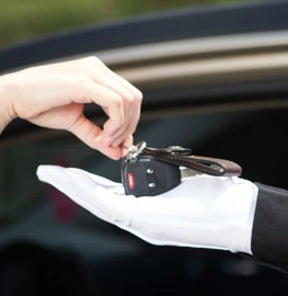 One Hand giving key to Second Hand near car